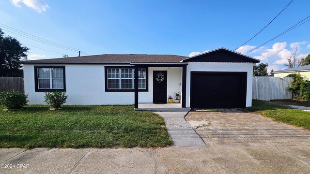 ranch-style house featuring a garage and a front lawn