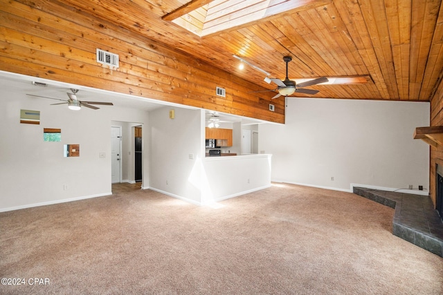 unfurnished living room with carpet floors, wood ceiling, and a skylight