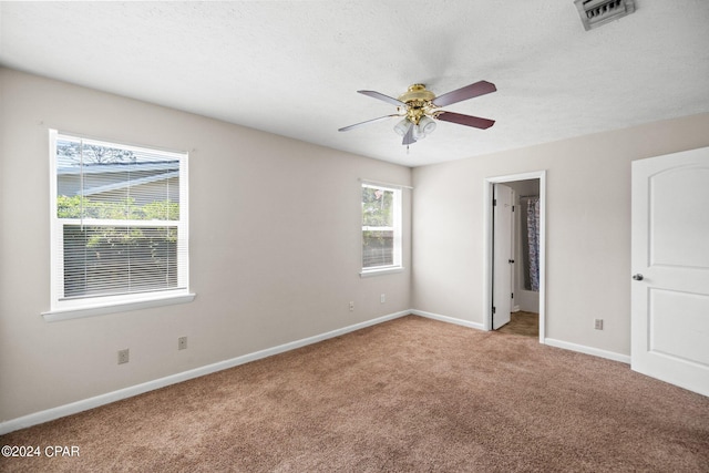 unfurnished bedroom featuring carpet, visible vents, baseboards, and ceiling fan