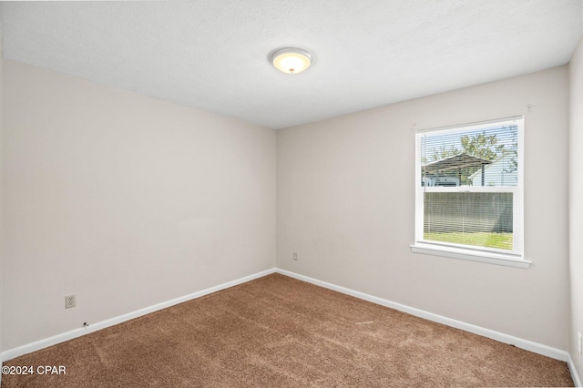 empty room with a textured ceiling and carpet