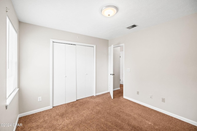 unfurnished bedroom with carpet and a closet