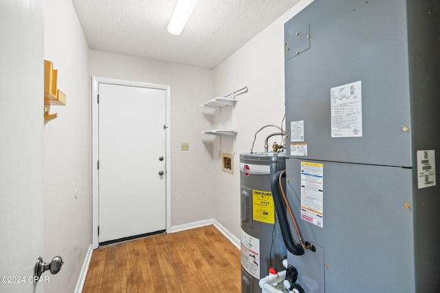 utility room with heating unit and electric water heater