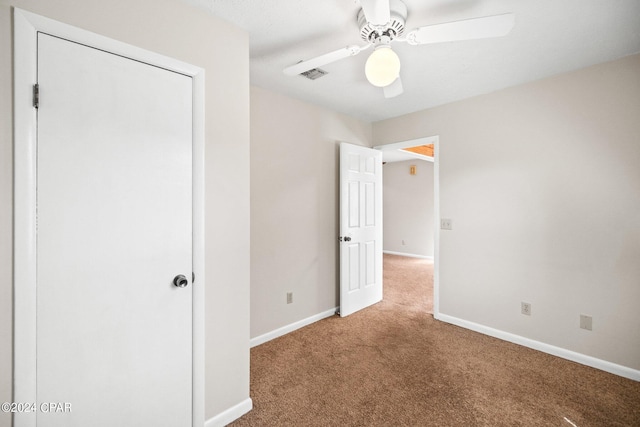 unfurnished bedroom with ceiling fan, a closet, and carpet flooring