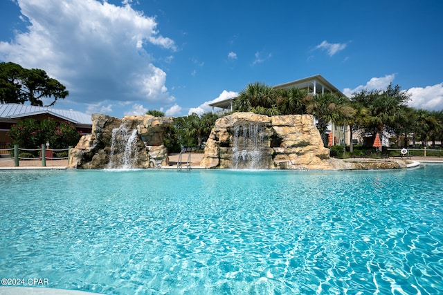 view of swimming pool with pool water feature