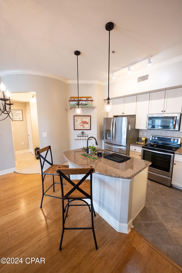 kitchen featuring decorative light fixtures, appliances with stainless steel finishes, dark wood-type flooring, tasteful backsplash, and track lighting