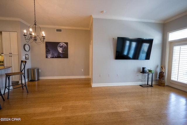 living room featuring ornamental molding, an inviting chandelier, and light wood-type flooring