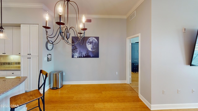 dining area featuring a notable chandelier, light hardwood / wood-style flooring, and ornamental molding