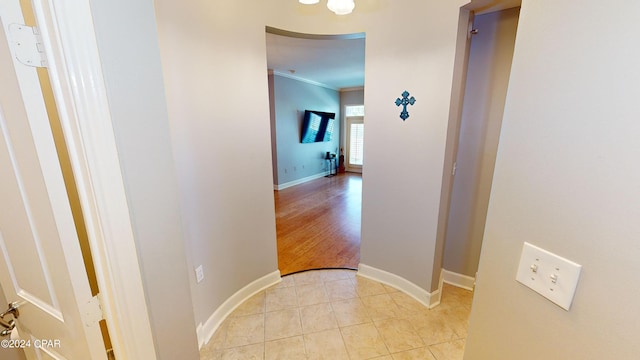 hallway with crown molding and light hardwood / wood-style floors