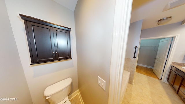 bathroom with wood-type flooring, vanity, and toilet