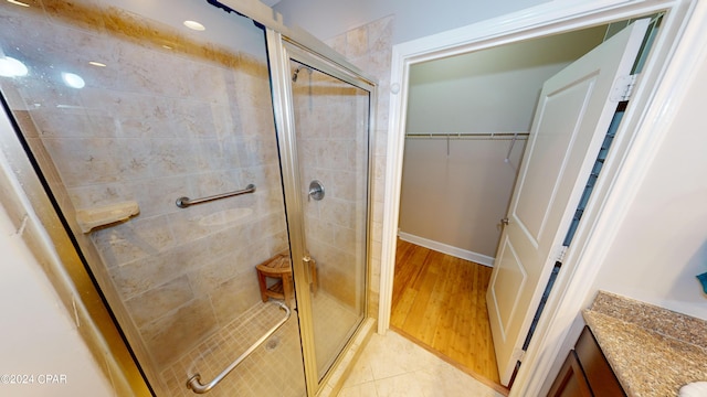 bathroom with hardwood / wood-style flooring and walk in shower