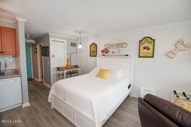 bedroom with crown molding, a textured ceiling, hardwood / wood-style floors, and a closet