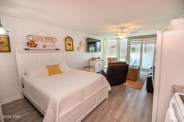 bedroom featuring ceiling fan, white fridge, and light hardwood / wood-style flooring