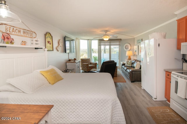 bedroom featuring ornamental molding, white refrigerator, hardwood / wood-style flooring, and ceiling fan