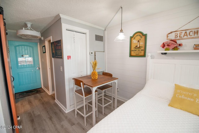 interior space featuring crown molding, a textured ceiling, and wood-type flooring