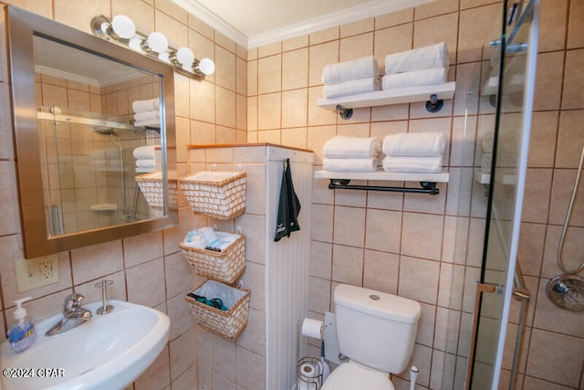 bathroom with tile walls, toilet, sink, and walk in shower