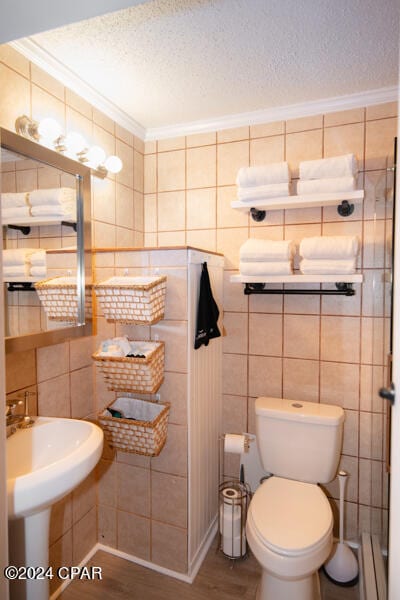 bathroom with tile walls and a textured ceiling