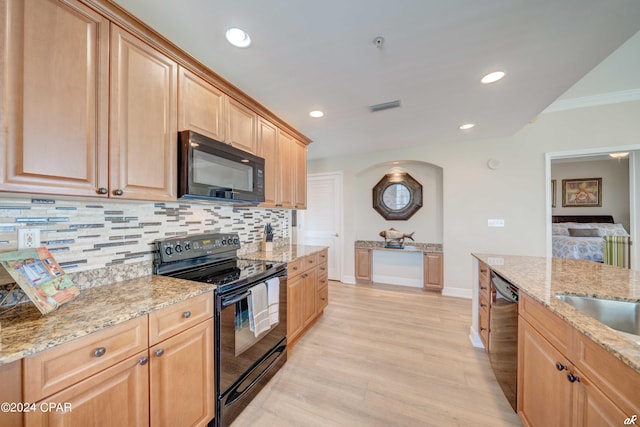 kitchen with backsplash, light hardwood / wood-style floors, black appliances, light brown cabinets, and light stone countertops