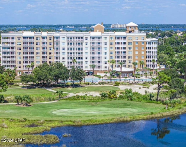 surrounding community with a water view and a lawn