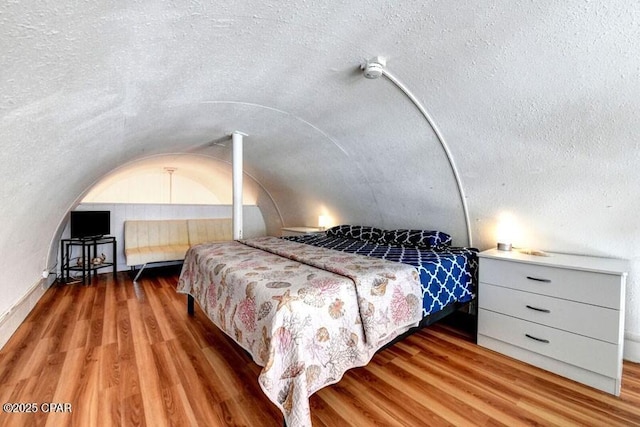 bedroom featuring lofted ceiling and hardwood / wood-style floors