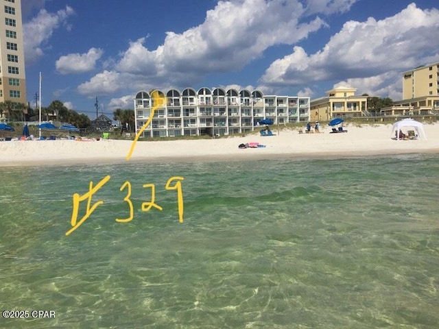 view of property's community with a beach view and a water view