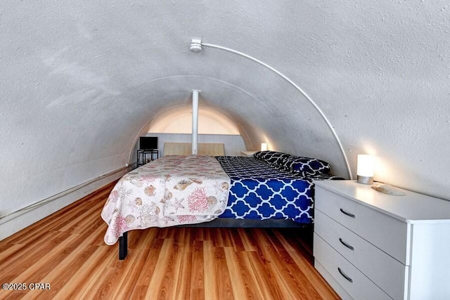 bedroom with vaulted ceiling and light hardwood / wood-style flooring