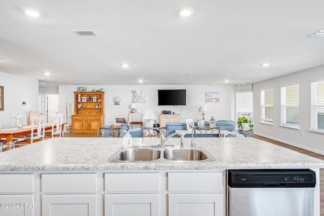 kitchen with sink, stainless steel dishwasher, white cabinetry, and wood-type flooring