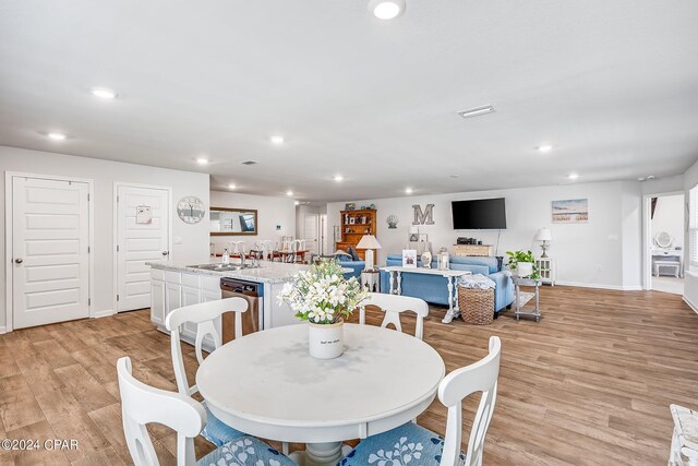 dining space featuring sink and light hardwood / wood-style floors