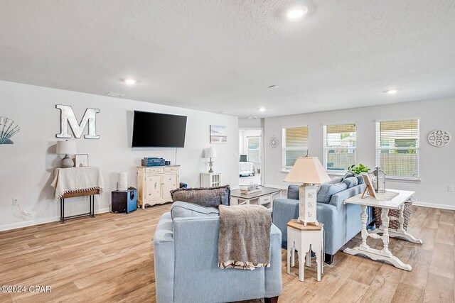 living room featuring light hardwood / wood-style flooring and a textured ceiling