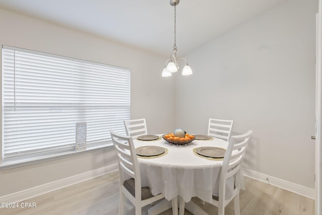 dining space featuring light wood-type flooring and a chandelier