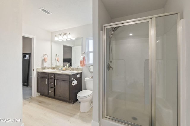 bathroom featuring a shower with door, vanity, toilet, and wood-type flooring