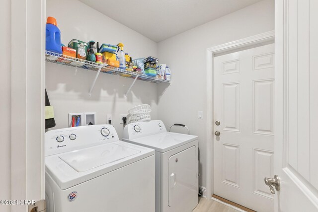 clothes washing area with light wood-type flooring and independent washer and dryer