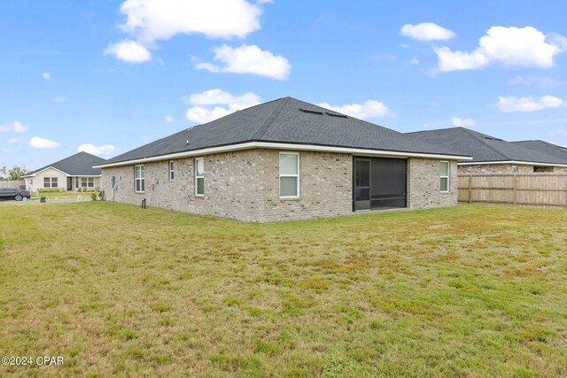 rear view of property with a yard