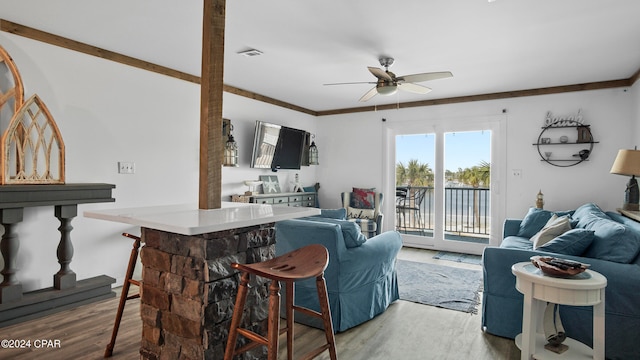 living room featuring ceiling fan, crown molding, and wood-type flooring