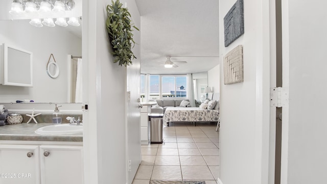 corridor with sink and light tile patterned floors