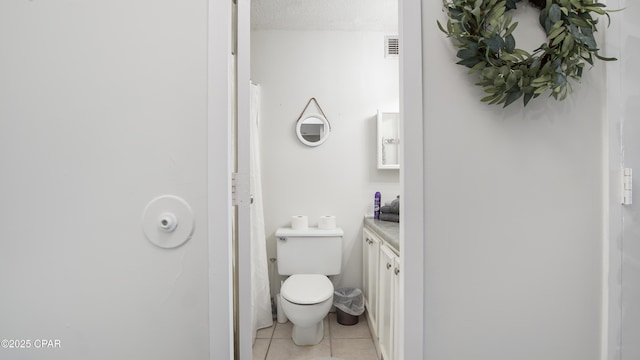 bathroom featuring vanity, toilet, tile patterned flooring, and a textured ceiling