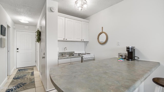 kitchen featuring light tile patterned flooring, sink, white cabinetry, a textured ceiling, and white electric stove