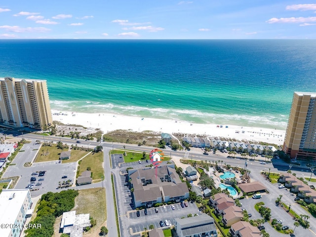 birds eye view of property with a water view and a beach view