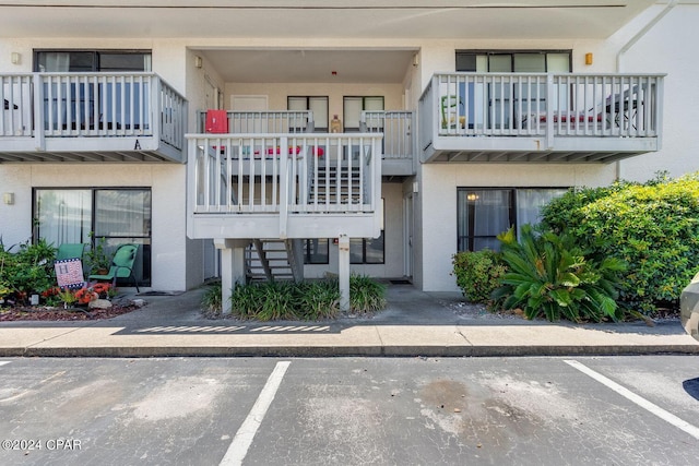 view of property with uncovered parking and stairway