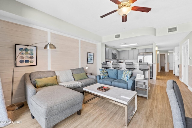 living room featuring light hardwood / wood-style flooring and ceiling fan