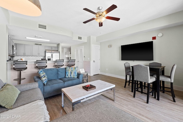 living room with light wood-type flooring and ceiling fan