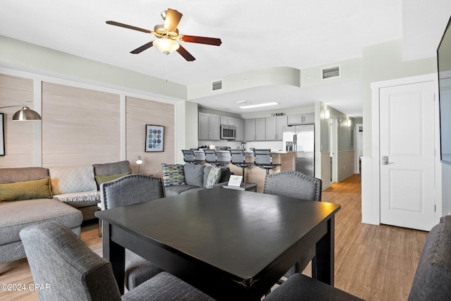 dining area with light wood-type flooring and ceiling fan