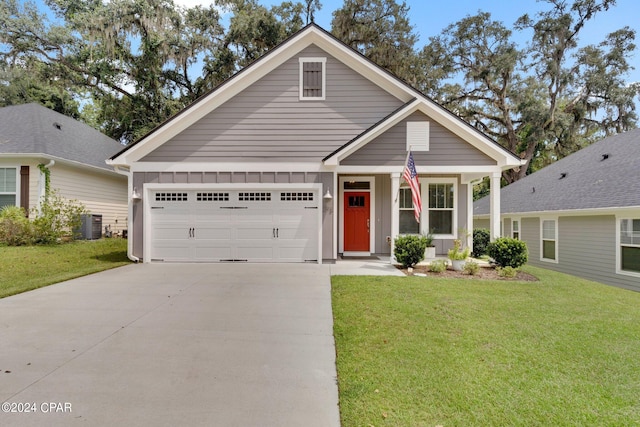 view of front facade featuring a garage, cooling unit, and a front yard