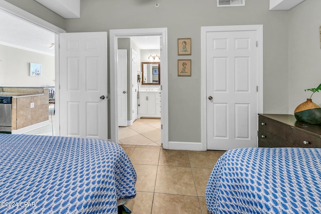 bedroom with visible vents, baseboards, ornamental molding, ensuite bath, and light tile patterned floors