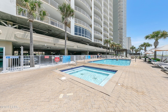 pool featuring a hot tub, fence, and a patio area