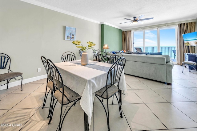 dining space featuring crown molding, a textured ceiling, light tile patterned floors, baseboards, and ceiling fan
