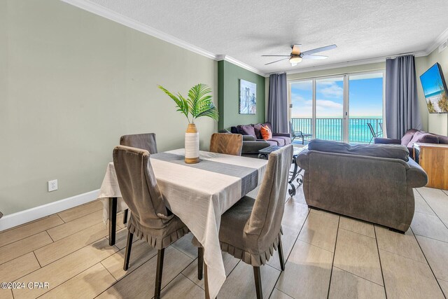 dining space featuring ceiling fan, crown molding, and a textured ceiling