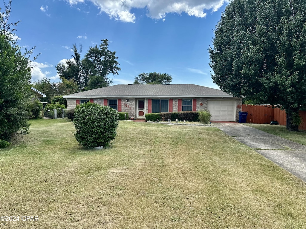 1021 W W 28th Pl, Panama City, FL 32405 - ranch-style house with aphalt driveway, fence, a garage, and a front lawn