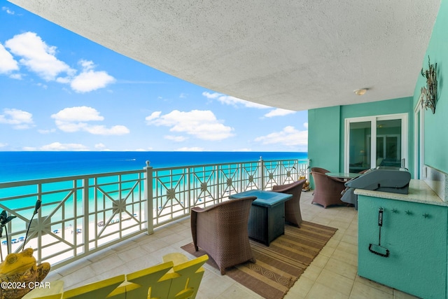 balcony featuring a grill, a water view, and a beach view