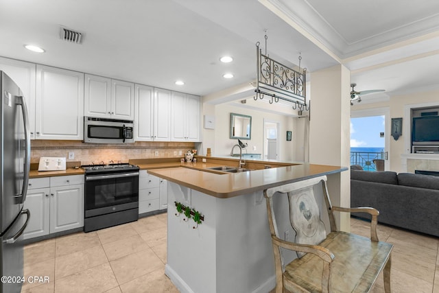 kitchen featuring sink, tasteful backsplash, white cabinetry, stainless steel appliances, and crown molding