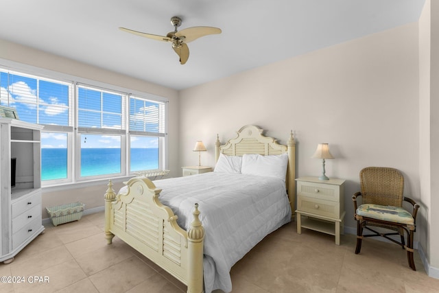 tiled bedroom with a water view and ceiling fan